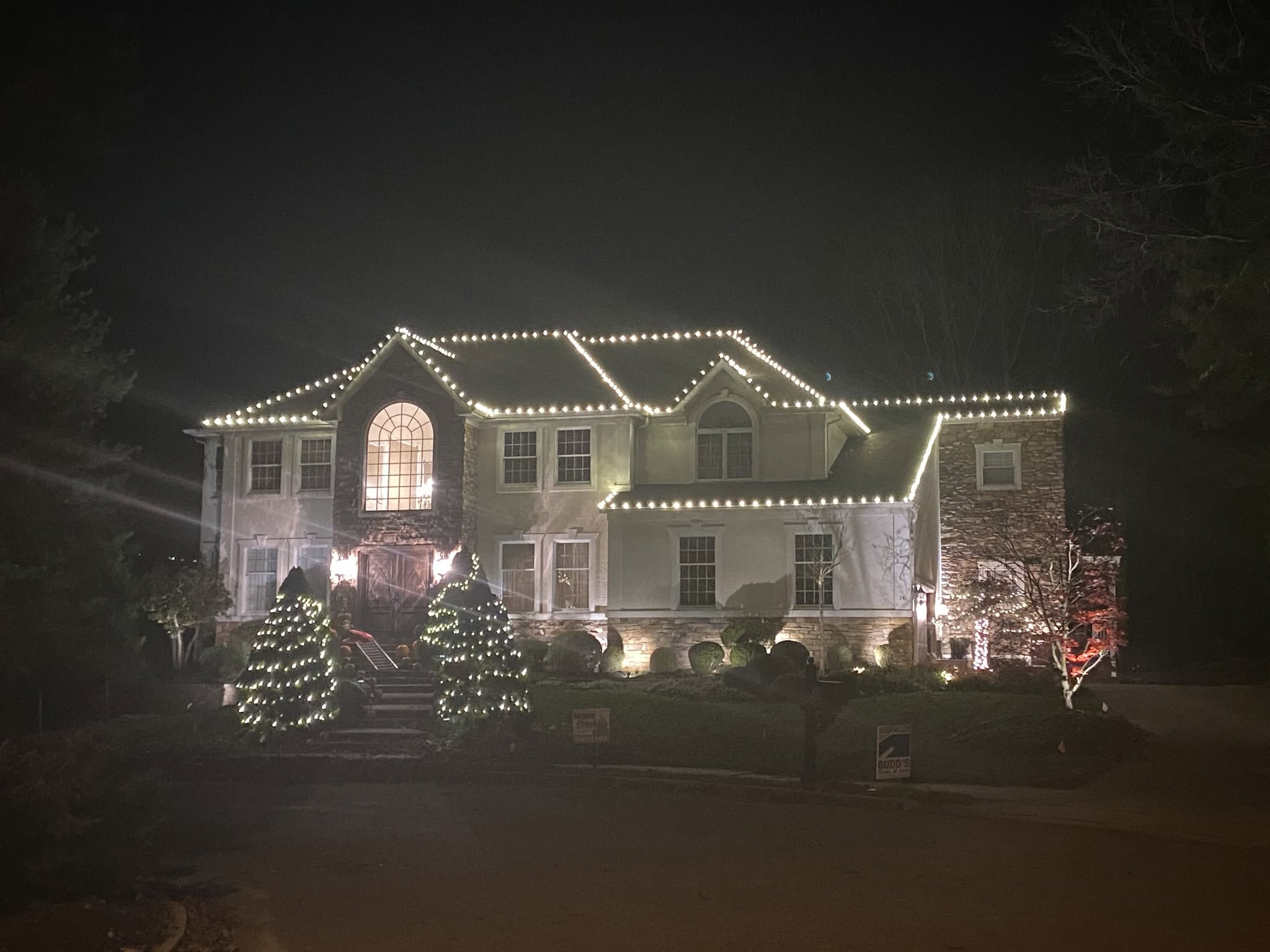 Professional Christmas light installation on a Moorestown NJ home with warm white roofline and landscape lighting