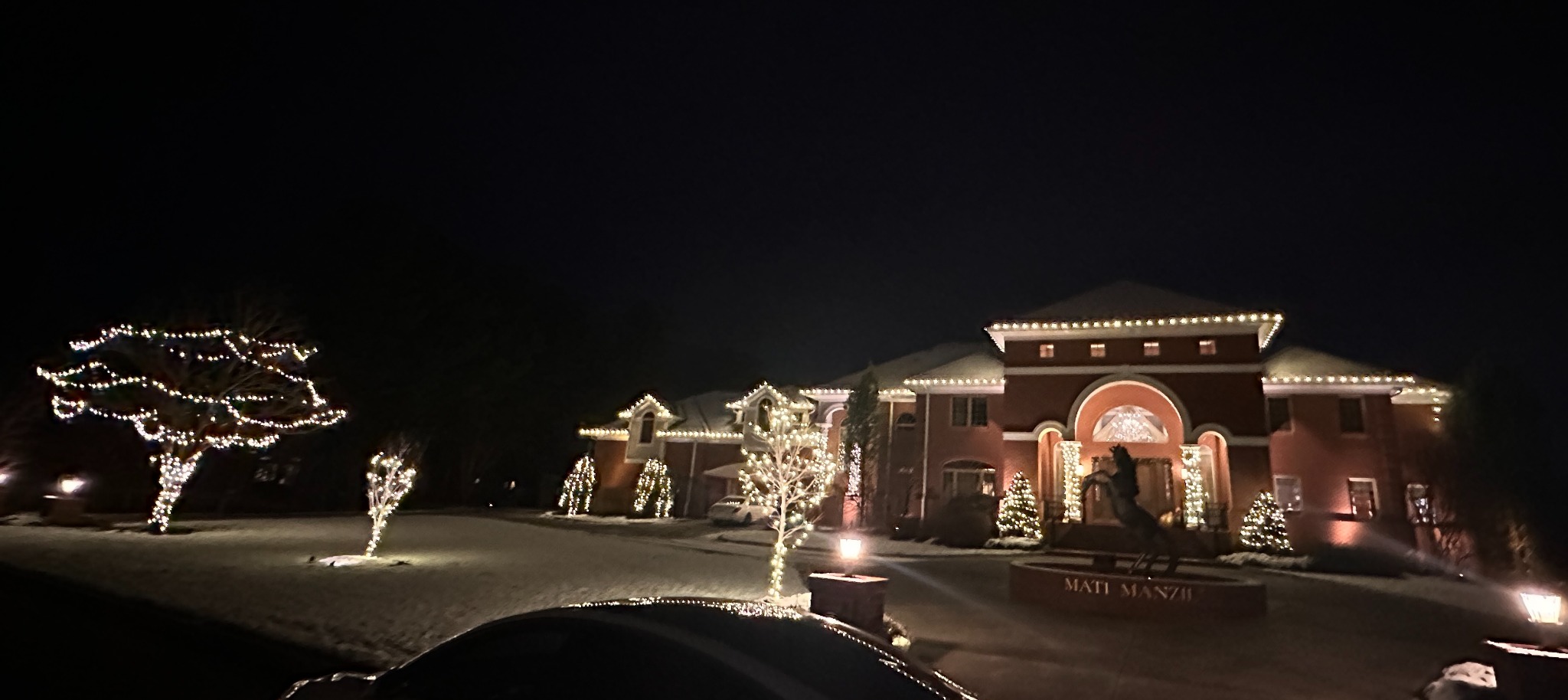 Professional warm white Christmas light installation on a large Moorestown NJ home with roofline, tree and landscape lighting
