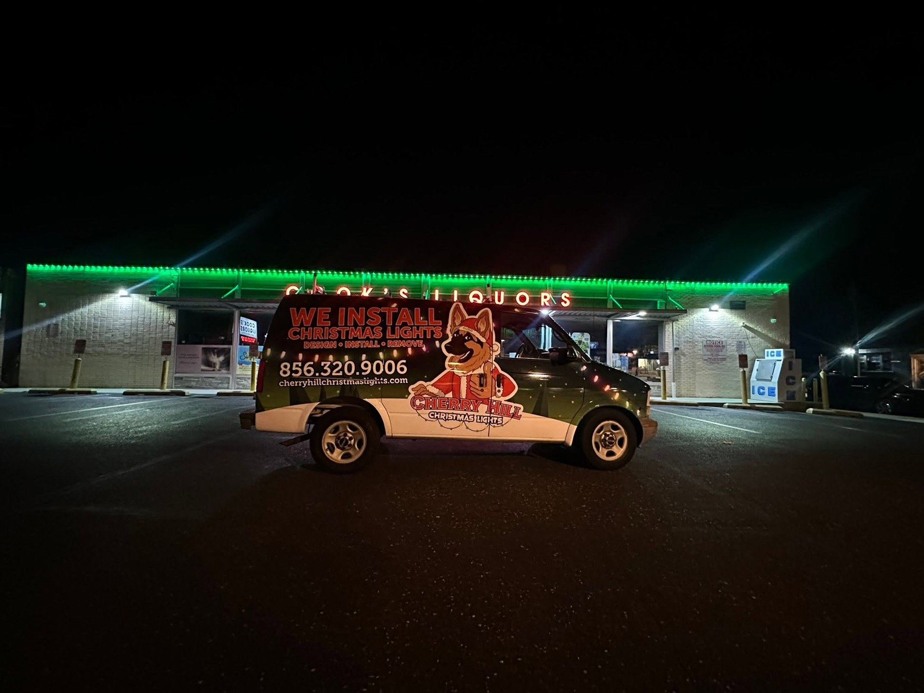 Cherry Hill Christmas Lights service van in front of a business with green permanent roofline lights